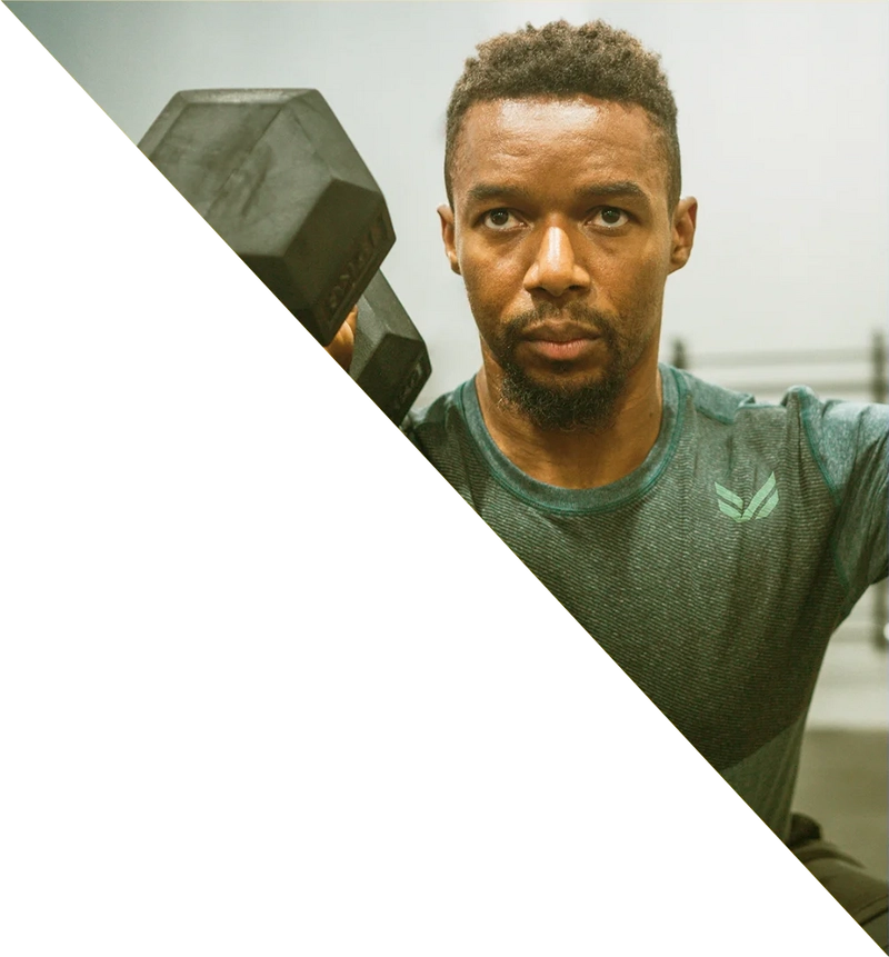 A fit man in the squat position after perform a dumbell snactch