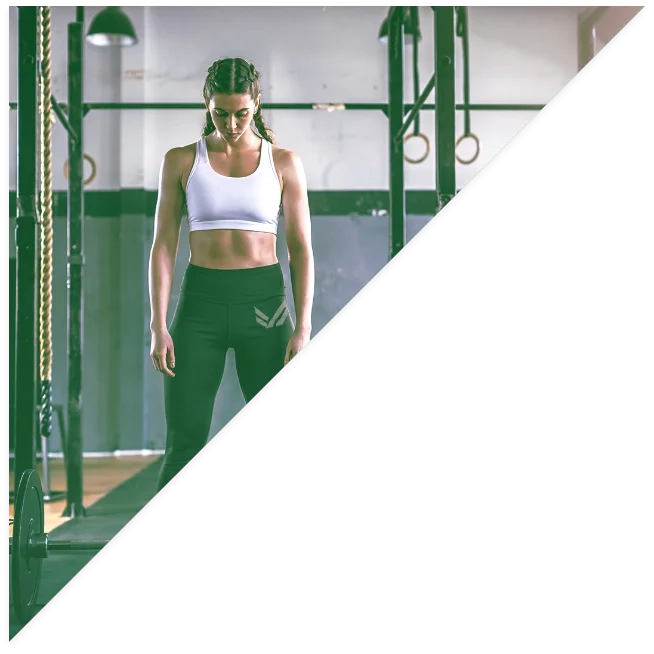 A fit woman looking down at her olympic bar